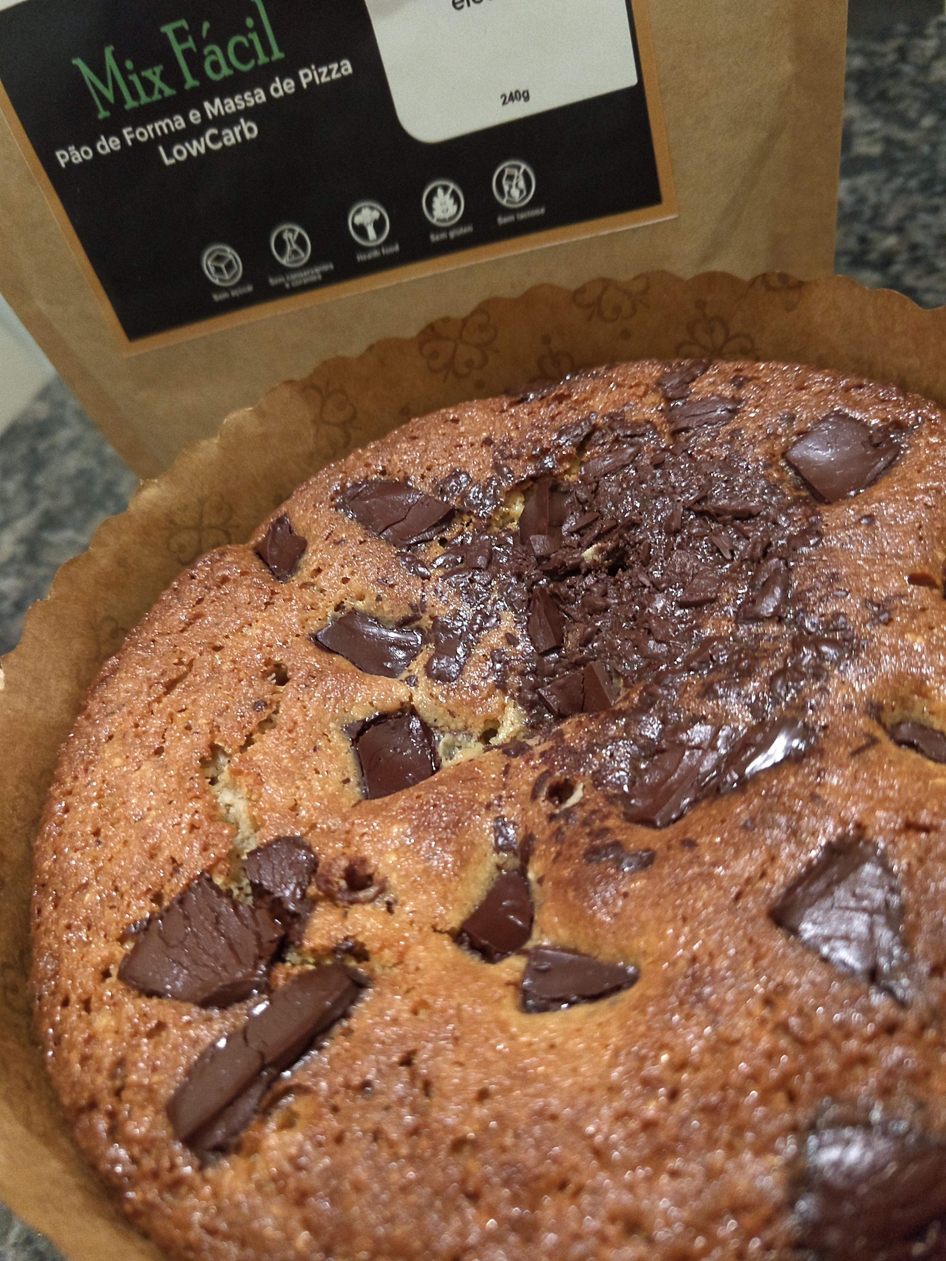 Chocotone Low Carb já assado com o Mix Fácil de fundo, coloração amarronzada e brilhante, com chocolate picado, agora derretido, por cima.